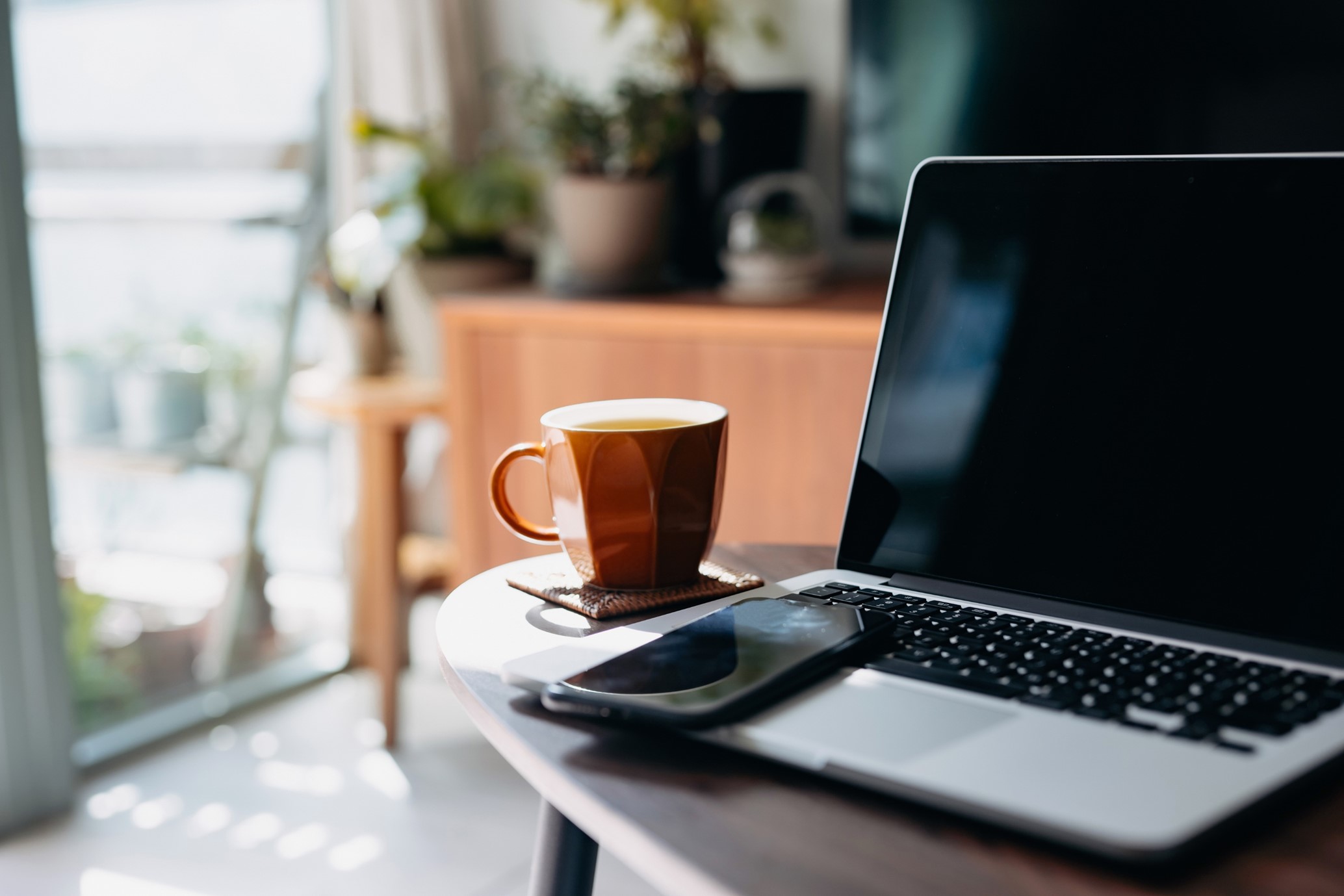 Laptop with smartphone and coffee cup
